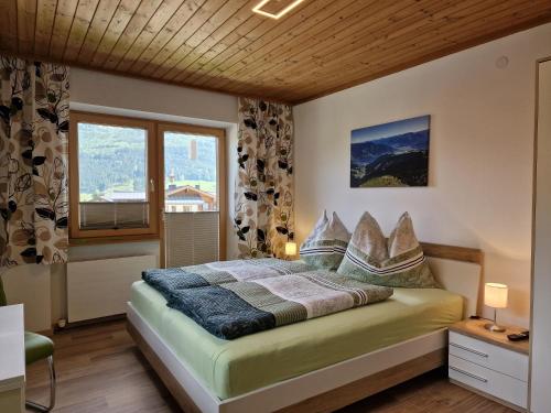 Schlafzimmer mit einem Bett und einem Fenster in der Unterkunft Haus Höllerer in Uttendorf