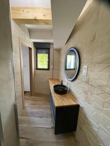 La salle de bains est pourvue d'un lavabo et d'un miroir. dans l'établissement six fours les plages logement maison, à Six-Fours-les-Plages