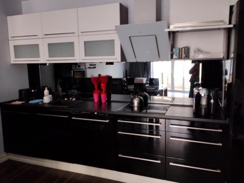 een keuken met zwarte aanrechtbladen en witte kasten bij Apartament studio in Głogów