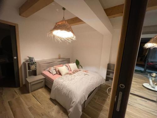 a bedroom with a bed and a pendant light at six fours les plages logement maison in Six-Fours-les-Plages