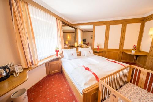 ein Schlafzimmer mit einem großen Bett und einem Fenster in der Unterkunft Hotel am Schlosspark Zum Kurfürst in Oberschleißheim
