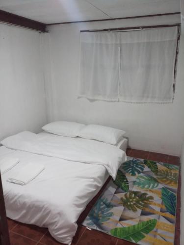 a bedroom with two beds and a window and a rug at บ้านน่านโฮมสเตย์ in Nan