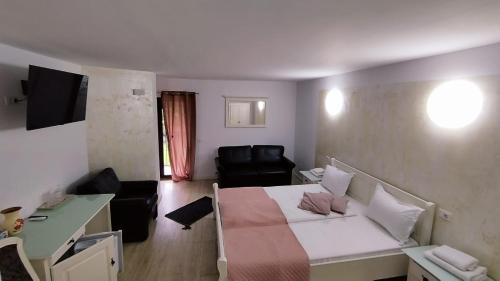 a small living room with a bed and a couch at LA RĂSCRUCE DE APE in Suceviţa
