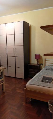 a bedroom with a bed and a dresser and cabinets at Appartamento Varese in Varese