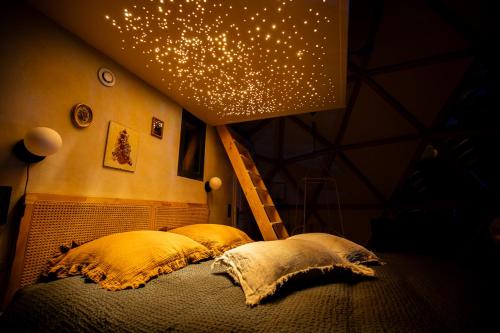 a bed with two pillows and a staircase in a room at Dôme panoramique tout confort au cœur du Vercors in Autrans