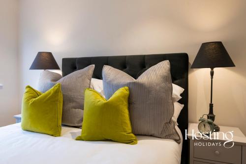 1 dormitorio con 1 cama con almohadas amarillas en The Oars Apartment - Marlow - Parking Included en Marlow