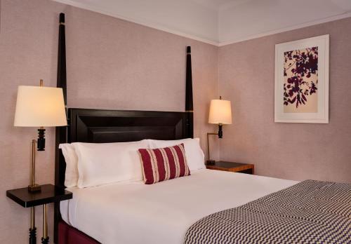 a bedroom with a large white bed with two lamps at St. Ermin's Hotel, Autograph Collection in London