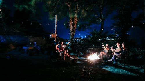a group of people sitting around a fire at night at Wine Space in Ambrolauri