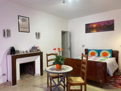 un salon avec une table et un lit dans l'établissement Chambre équipée Plain-Pied - 2 pers avec sdb wc privé, à Hargeville