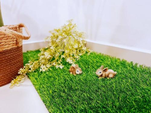 two toy animals sitting on a patch of green grass at New! 4-6pax Mount Austin High Condo in Johor Bahru in Johor Bahru