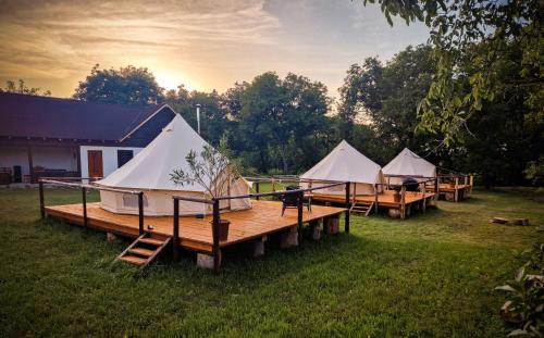 a group of three tents sitting on a dock at Pensiunea Cocoș 