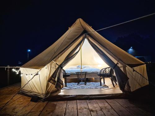 a tent with a table and a chair in it at Pensiunea Cocoș 