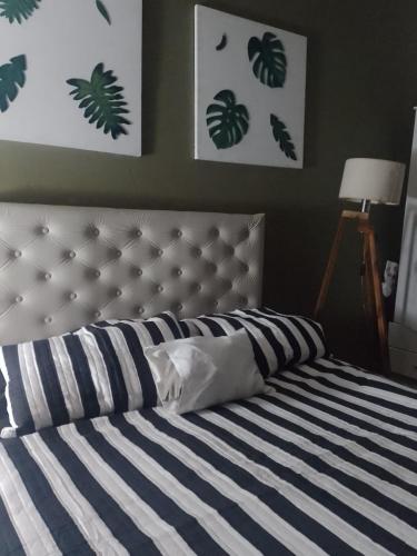 a bedroom with a bed with a blue and white stripes at La familia in Ezeiza