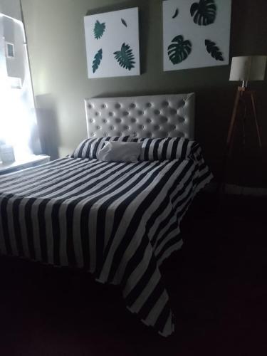 1 cama con edredón de rayas blanco y negro en La familia en Ezeiza