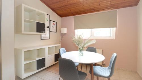 a dining room with a white table and chairs at Family beach house near airport in Artemida