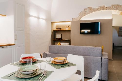 - une salle à manger avec une table, des chaises et un canapé dans l'établissement Dal Monaco - casa vacanze, à Castellana Grotte