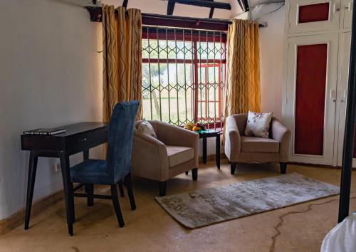 a living room with a desk and chairs and a window at Maanzoni - Ndoto House ,Athi River by Nest & Nomad in Machakos
