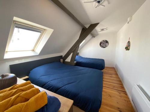 Cette chambre comprend 2 lits bleus et une fenêtre. dans l'établissement Appartement T3 en plein cœur du centre-ville, à Soissons