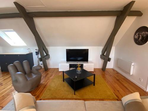 - un salon avec un canapé et une télévision dans l'établissement Appartement T3 en plein cœur du centre-ville, à Soissons