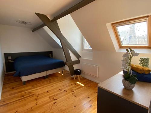 - une chambre mansardée avec un lit bleu dans l'établissement Appartement T3 en plein cœur du centre-ville, à Soissons
