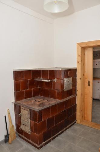 a brick fireplace in the middle of a room at Вершище in Urych