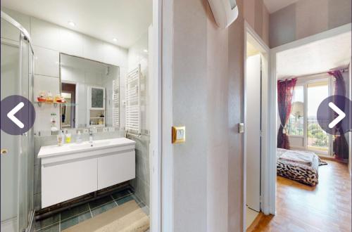 bagno bianco con lavandino e specchio di Chambre dans appartement chez habitants À côté du Lac et du Casino a Épinay-sur-Seine