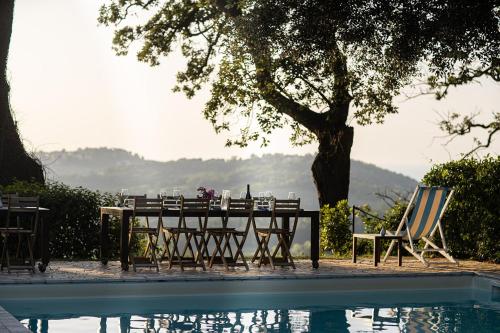 a table and chairs next to a swimming pool at Castello di Granarola Relais - Adults Friendly - in Gradara