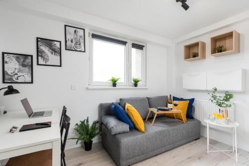 ein Wohnzimmer mit einem Sofa und einem Schreibtisch in der Unterkunft Czarnowiejska Mini Studio in Krakau