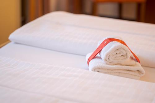 a stack of towels sitting on top of a bed at Chalét zum Kurfürst in Oberschleißheim