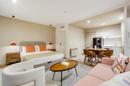 Habitación de hotel con cama y sala de estar. en Home Art Apartments Salamanca en Madrid