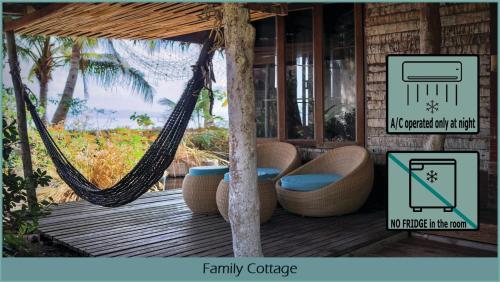 a hammock on a porch with a sign that reads family cottage at Coco Cottage - SHA Plus in Ko Ngai