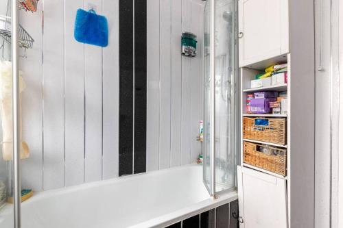 a bathroom with white walls and a glass shelf at Seaview in London