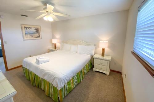 um quarto com uma cama, 2 candeeiros e uma janela em Island Charm em St. George Island