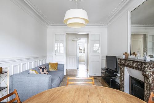 un salon avec un canapé et une cheminée dans l'établissement Pick A Flat's Apartment near Moulin Rouge - Rue Fontaine, à Paris