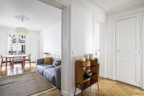 un salon avec un canapé et une table dans l'établissement Pick A Flat's Apartment near Moulin Rouge - Rue Fontaine, à Paris