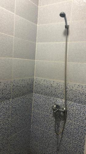 a shower in a bathroom with a tiled wall at Driouch 2 slaapkamers in Driouch