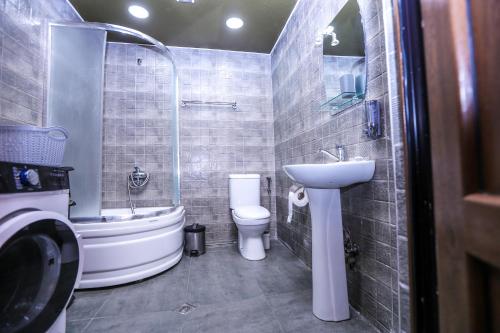 a bathroom with a sink and a tub and a toilet at Tbilisi Tower Apartment in Tbilisi City