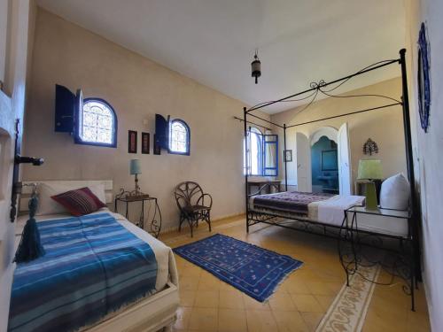 a bedroom with two beds and a mirror at Dar janoub in El Jadida