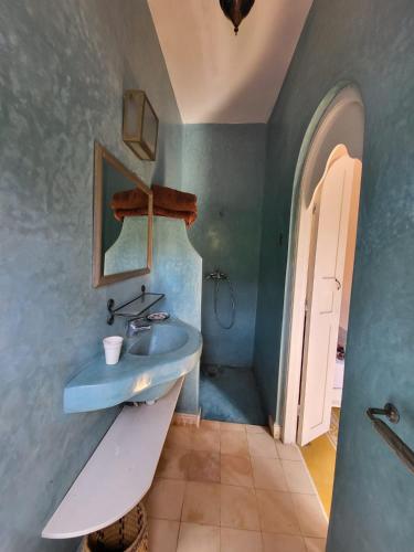 a bathroom with a blue sink and a white door at Dar janoub in El Jadida