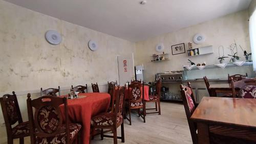 a dining room with tables and chairs and a stove at LA RĂSCRUCE DE APE in Suceviţa