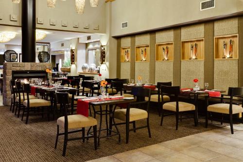a dining room with tables and chairs in a restaurant at Protea Hotel by Marriott Bloemfontein Willow Lake in Bloemfontein