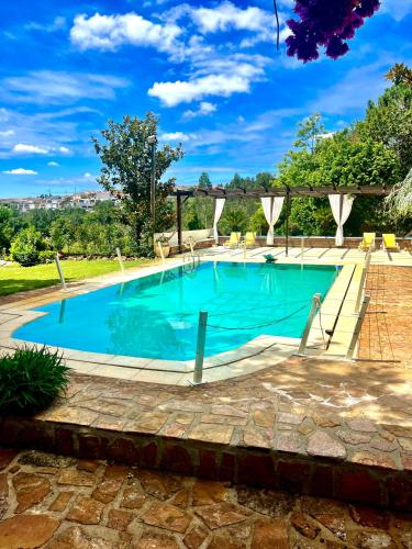 a swimming pool in a yard with a brick patio at Bouça do Sossego in Ribeirão