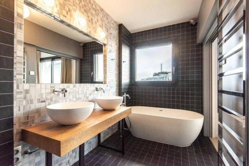 une salle de bain avec deux lavabos et une baignoire et une baignoire dans l'établissement LuxuriousFlat#VictorHugo#Trocadero#ViewEffeilTower, à Paris