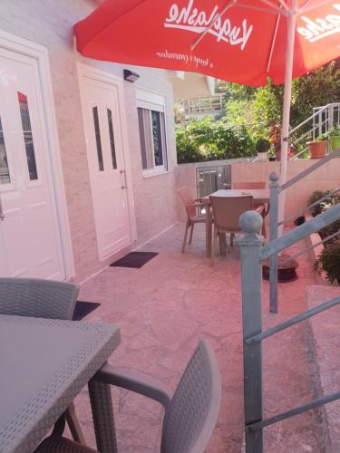 a patio with an umbrella and a table and chairs at RIAN GUEST HOUSE in Sarandë