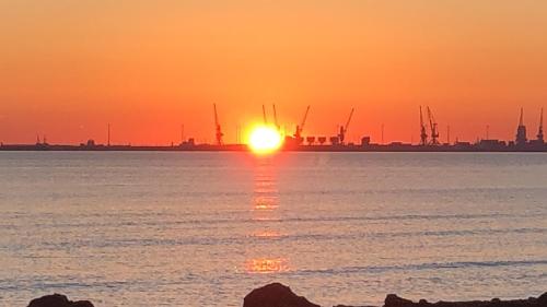 a sunset over a body of water with a city in the background at Sunrise Hotel Cameria in Durrës
