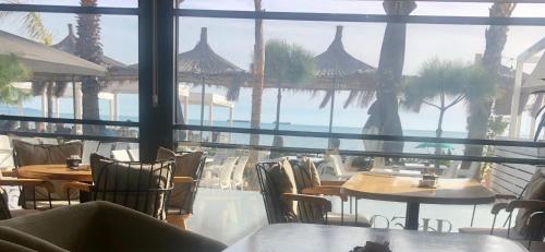 a restaurant with tables and chairs and a view of the ocean at Sunrise Hotel Cameria in Durrës