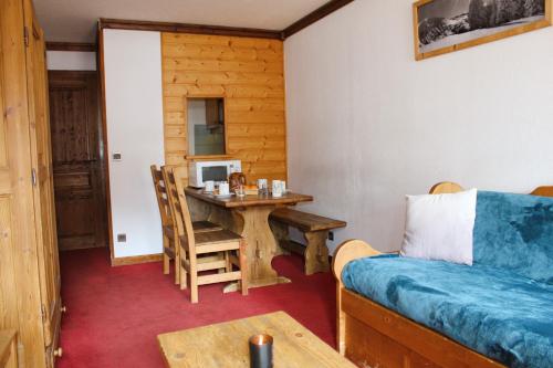 een woonkamer met een tafel en een bank bij Résidence Alpina Lodge by Valdiski in Val dʼIsère
