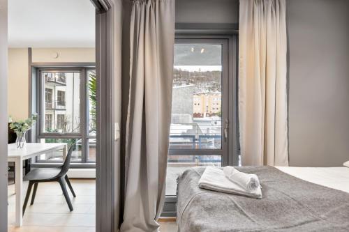a bedroom with a bed and a table and a window at Forenom Serviced Apartments Oslo Munch in Oslo