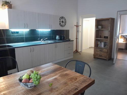 a kitchen with a table with a bowl of fruit on it at Apartmán Maya in Pardubice