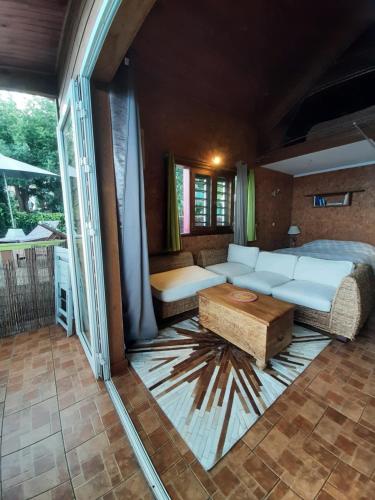 een slaapkamer met een bed, een bank en een tafel bij La Kaz Ouale in Saint-Leu